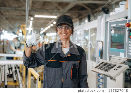 Happy, showing thumb up gesture. Woman is in the window making factory Happy, showing thumb up gesture. Woman is in the window making factory 137827048