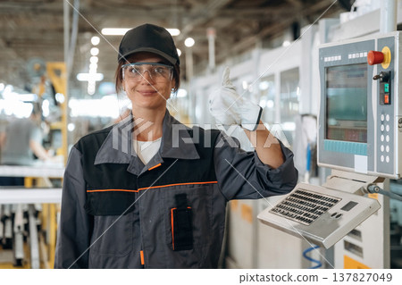 Happy, showing thumb up gesture. Woman is in the window making factory Happy, showing thumb up gesture. Woman is in the window making factory 137827049