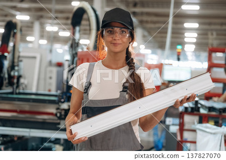 Plank in hands, standing. Woman is in the window making factory Plank in hands, standing. Woman is in the window making factory 137827070