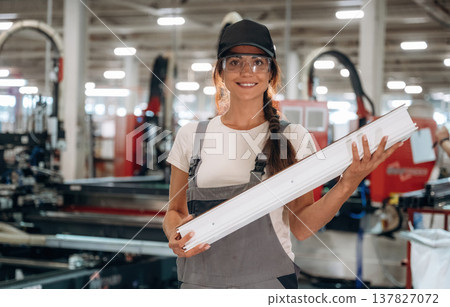 Plank in hands, standing. Woman is in the window making factory Plank in hands, standing. Woman is in the window making factory 137827072