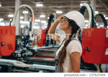 Professional occupation, standing. Woman is in the window making factory Professional occupation, standing. Woman is in the window making factory 137827094