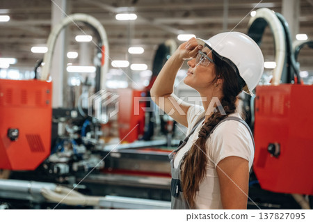 In protective glasses. Woman is in the window making factory In protective glasses. Woman is in the window making factory 137827095