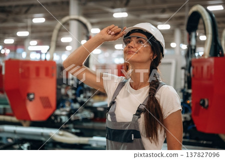 In protective glasses. Woman is in the window making factory 137827096