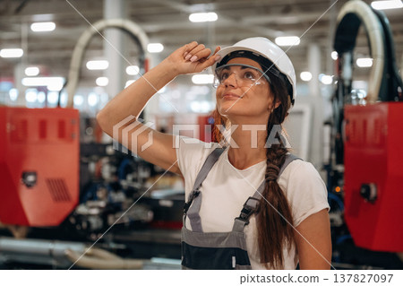 In protective glasses. Woman is in the window making factory In protective glasses. Woman is in the window making factory 137827097