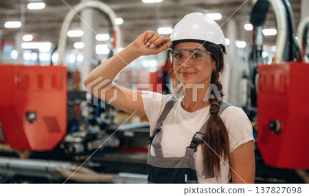 In protective glasses. Woman is in the window making factory 137827098