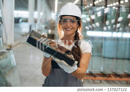 Employee is on the job. Woman is in the window making factory Employee is on the job. Woman is in the window making factory 137827122