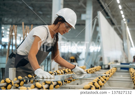 Pieces of new glass, on the production line. Woman is in the window making factory Pieces of new glass, on the production line. Woman is in the window making factory 137827132