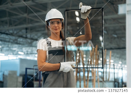 Employee is on the job. Woman is in the window making factory Employee is on the job. Woman is in the window making factory 137827145