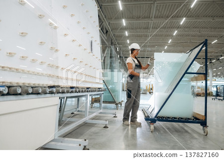Moving bunch of glass. Woman is in the window making factory Moving bunch of glass. Woman is in the window making factory 137827160