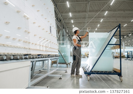 Moving bunch of glass. Woman is in the window making factory Moving bunch of glass. Woman is in the window making factory 137827161