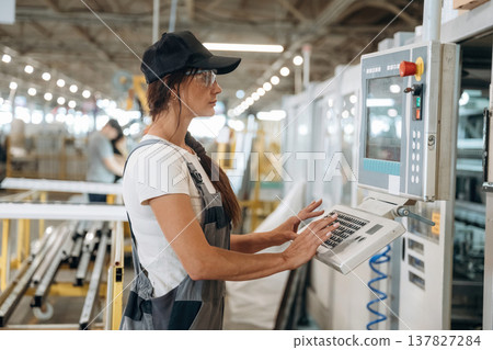 Machinery computer operator. Woman is in the window making factory Machinery computer operator. Woman is in the window making factory 137827284