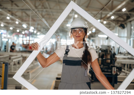 Modern window making factory, woman in professional uniform is standing 137827294