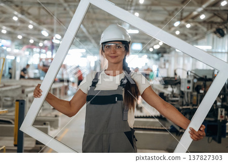 Big frame in hands. Woman is in the window making factory Big frame in hands. Woman is in the window making factory 137827303