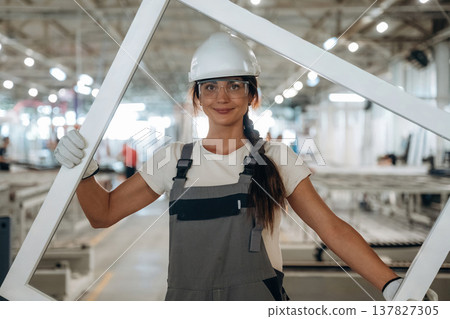 Empty frame is in hands. Woman is in the window making factory Empty frame is in hands. Woman is in the window making factory 137827305