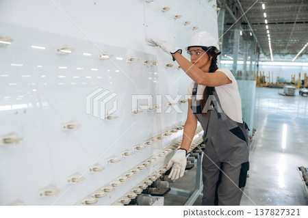 Placing the glass on the special wall. Woman is in the window making factory Placing the glass on the special wall. Woman is in the window making factory 137827321