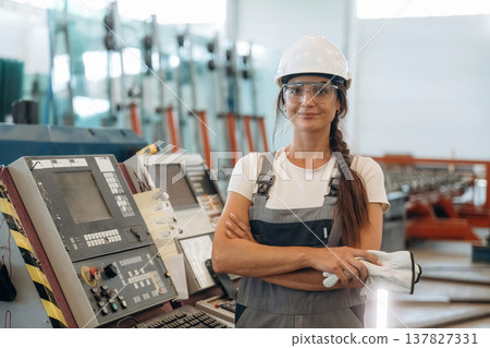 Arms crossed, standing and posing. Woman is in the window making factory Arms crossed, standing and posing. Woman is in the window making factory 137827331