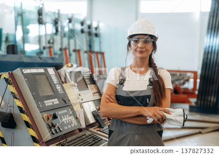 Manufacturing conception, standing. Woman is in the window making factory 137827332