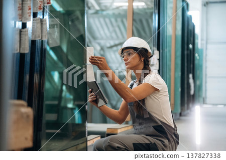 Checking the right amount. Woman is in the window making factory Checking the right amount. Woman is in the window making factory 137827338