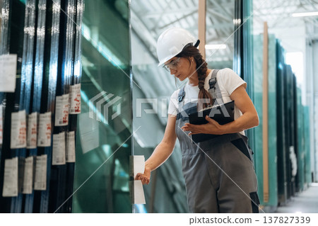 Checking the right amount. Woman is in the window making factory Checking the right amount. Woman is in the window making factory 137827339