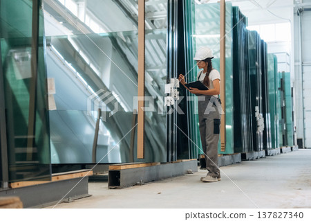 Bunch of glass. Woman is in the window making factory Bunch of glass. Woman is in the window making factory 137827340