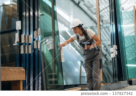 Bunch of glass. Woman is in the window making factory Bunch of glass. Woman is in the window making factory 137827342