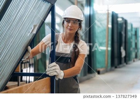 Moving the new batch of glass. Woman is in the window making factory Moving the new batch of glass. Woman is in the window making factory 137827349