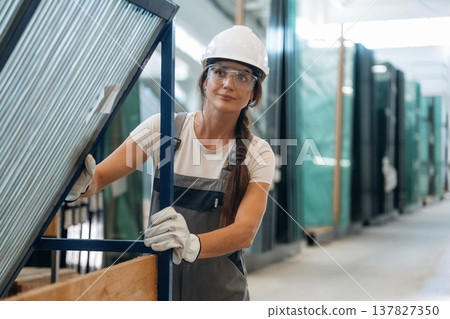 Moving the new batch of glass. Woman is in the window making factory Moving the new batch of glass. Woman is in the window making factory 137827350