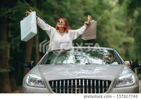 Going from the shopping, with bags. Senior couple driving convertible cabriolet car Going from the shopping, with bags. Senior couple driving convertible cabriolet car 137827748