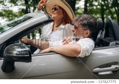 Comfortable vehicle, vacation conception. Senior couple driving convertible cabriolet car Comfortable vehicle, vacation conception. Senior couple driving convertible cabriolet car 137827775