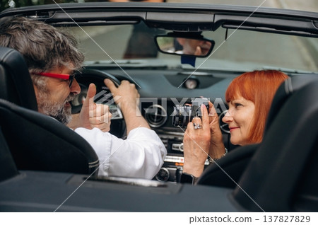 Back view. Senior couple driving convertible cabriolet car Back view. Senior couple driving convertible cabriolet car 137827829