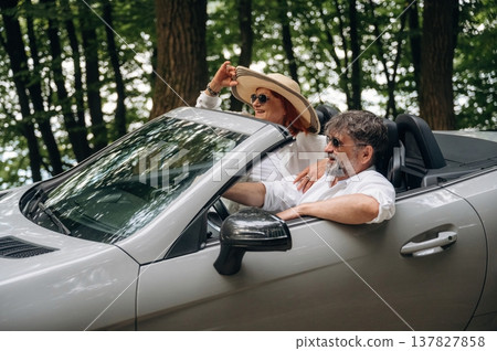 Comfortable vehicle, vacation conception. Senior couple driving convertible cabriolet car Comfortable vehicle, vacation conception. Senior couple driving convertible cabriolet car 137827858