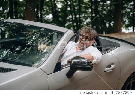 Vintage pilot glasses. Stylish senior man is in convertible cabriolet car Vintage pilot glasses. Stylish senior man is in convertible cabriolet car 137827899