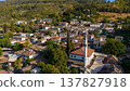 Aerial view of a traditional Turkish village with white houses, red roofs and a mosque surrounded by green hills. Scenic rural landscape and authentic architecture in Turkey. 137827918
