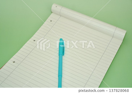 Blank Lined Notepad with Cyan Pen on Pastel Green Background 137828068