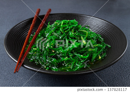 Chuka salad, made from fresh seaweed, with sesame dressing, served in a black bowl, with chopsticks, 137828117