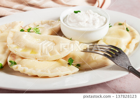 Traditional Georgian kvari dumplings, served with sour cream and herbs, close-up view, no people, Traditional Georgian kvari dumplings, served with sour cream and herbs, close-up view, no people, 137828123