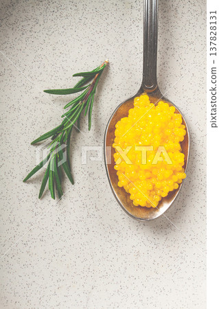 Yuzu caviar is pearly, on a spoon, top view, light background, no people. Yuzu caviar is pearly, on a spoon, top view, light background, no people. 137828131