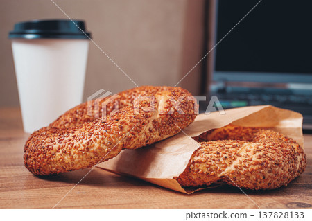 simits with coffee on a wooden table, with a laptop, in a cozy working environment, snack, breakfast, no people, 137828133