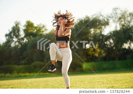 Cardio, running on the same place, exercise. Young fitness woman is on the field outdoors 137828244