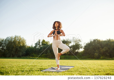 Classic tree yoga exercise for balance. Young fitness woman is on the field outdoors 137828248