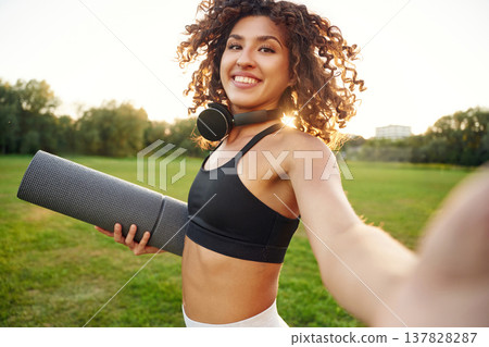 Photo for social media, doing selfie. Young fitness woman is on the field outdoors Photo for social media, doing selfie. Young fitness woman is on the field outdoors 137828287