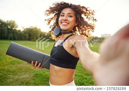 Photo for social media, doing selfie. Young fitness woman is on the field outdoors 137828289