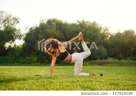 Hobby of fitness, doing exercises. Young woman is on the field outdoors Hobby of fitness, doing exercises. Young woman is on the field outdoors 137828294
