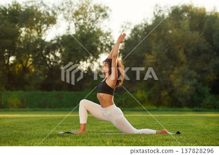 Hobby of fitness, doing exercises. Young woman is on the field outdoors 137828296