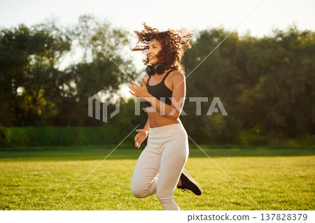 Cardio, running on the same place, exercise. Young fitness woman is on the field outdoors Cardio, running on the same place, exercise. Young fitness woman is on the field outdoors 137828379