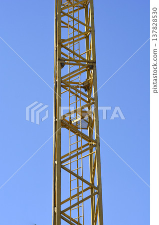 Yellow Tower Crane Mast Against Clear Blue Sky 137828530