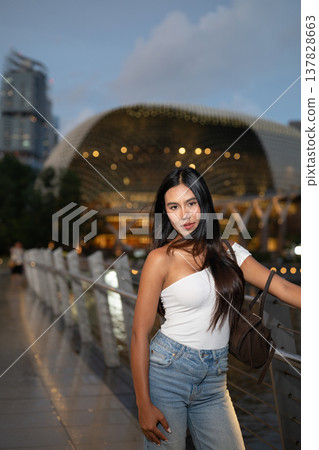 Asian tourist woman posing by the waterfront at Marina Bay Singapore during evening 137828663