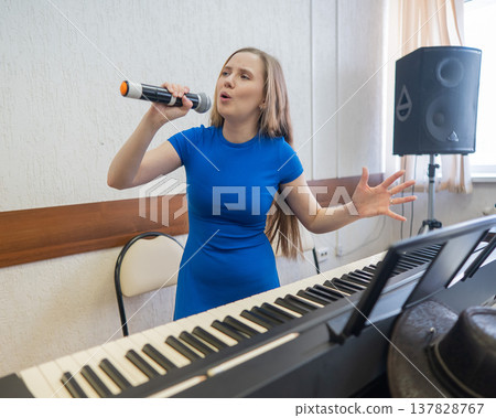 Caucasian woman singing into microphone. Caucasian woman singing into microphone. 137828767