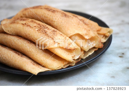 Delicious Homemade Bengali Patisapta Pitha Sweets Placed on a Dark Plate Delicious Homemade Bengali Patisapta Pitha Sweets Placed on a Dark Plate 137828923