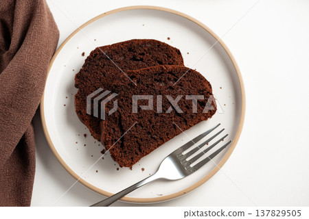 Slices of rich double chocolate pound cake on white plates. Top view Slices of rich double chocolate pound cake on white plates. Top view 137829505